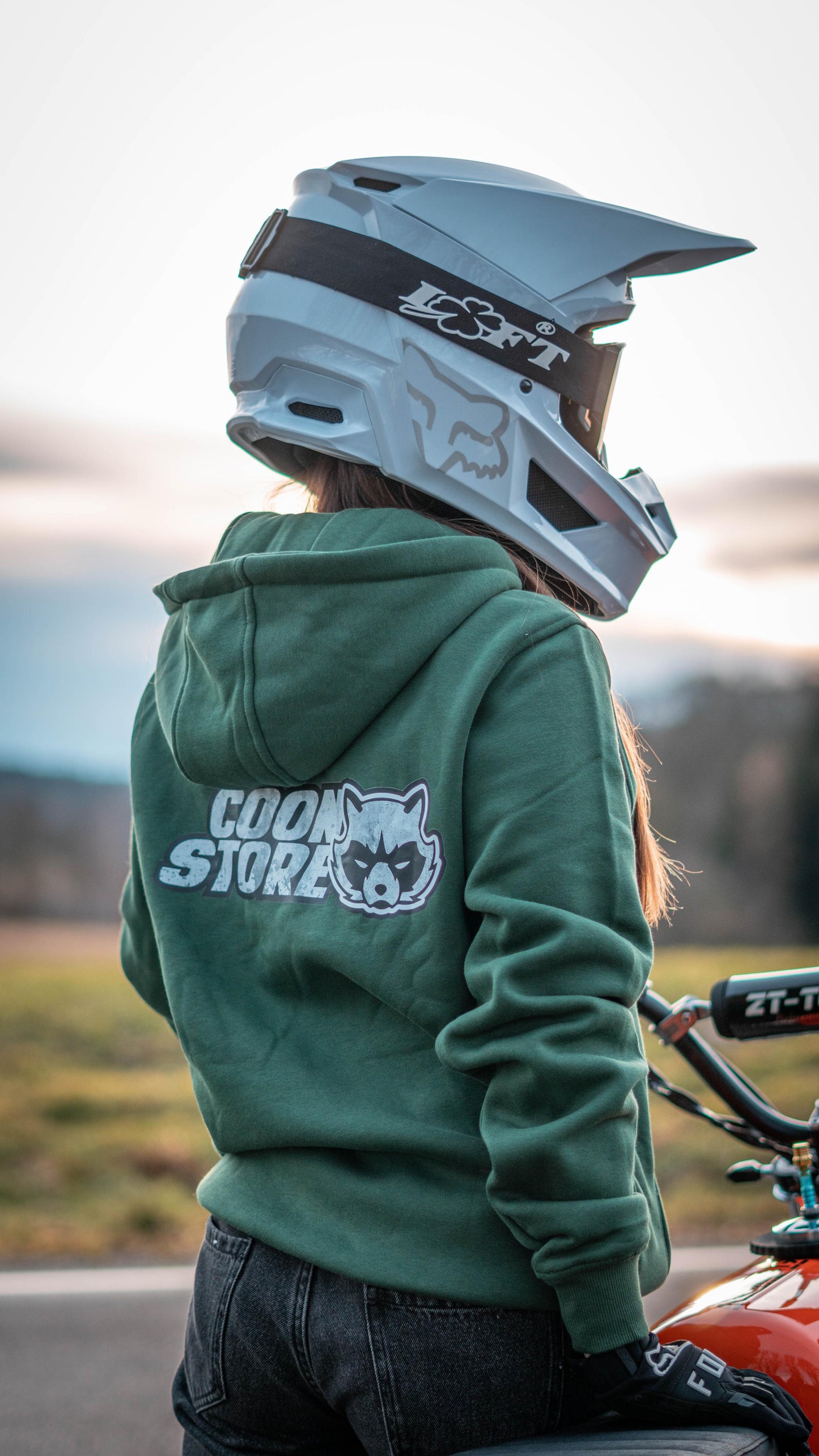 CoonStore Basic Hoodie in Lila, mit dem CoonStore Logo auf der Brust und Rücken, in normaler Passform. Der Hoodie besteht aus 65% Baumwolle und 35% Polyester, mit einer Grammatur von 300 g/m² für extra Komfort und Wärme. Ideal für Motocross-Fans, die ihren Style auch außerhalb der Strecke zeigen wollen. Der Hoodie ist in Dunkelgrün erhältlich und bietet eine weiche, bequeme Textur. Perfektes Merchandise für alle, die die Motocross-Kultur lieben.